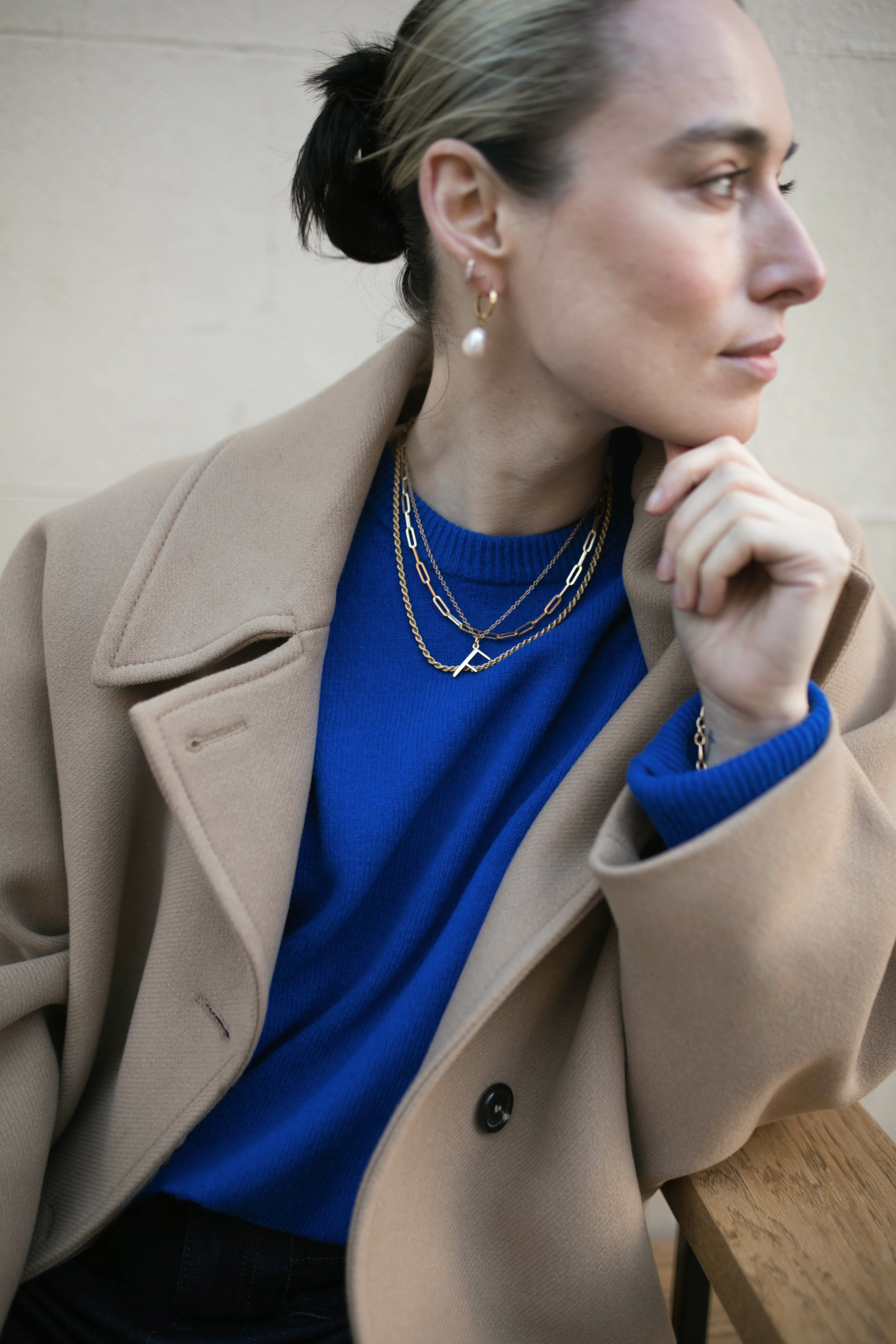 Model wearing F Anne Initial Necklace and several other Antonia Guise chains looking pensively to the right