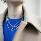 Close up of model wearing F necklace and several Antonia Guise chains. 