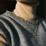 Close up of model wearing beige polar neck and our Mary Chain layered with our gold Marlene T-Bar Necklace
