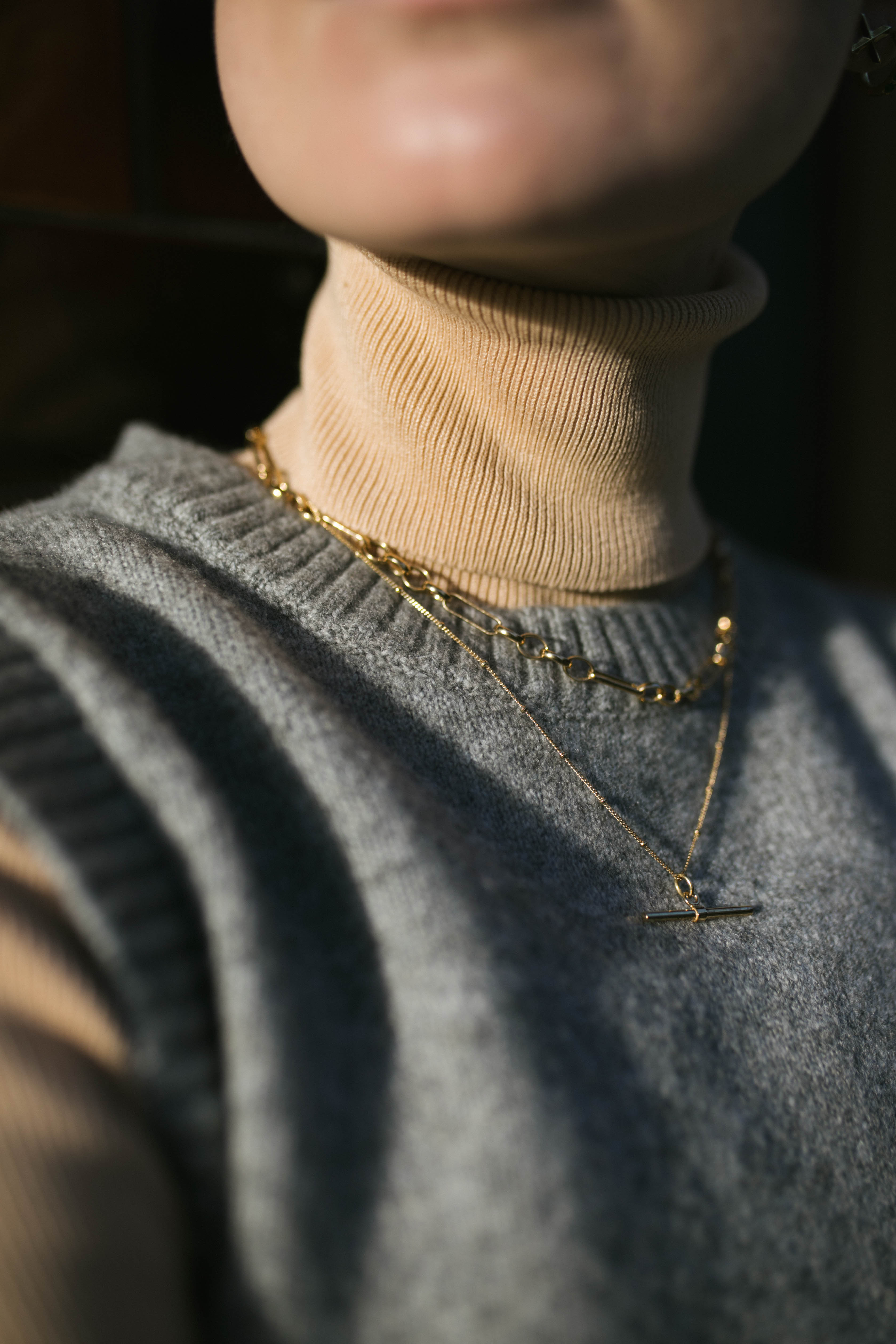 Close up of model wearing beige polar neck and our Mary Chain layered with our gold Marlene T-Bar Necklace
