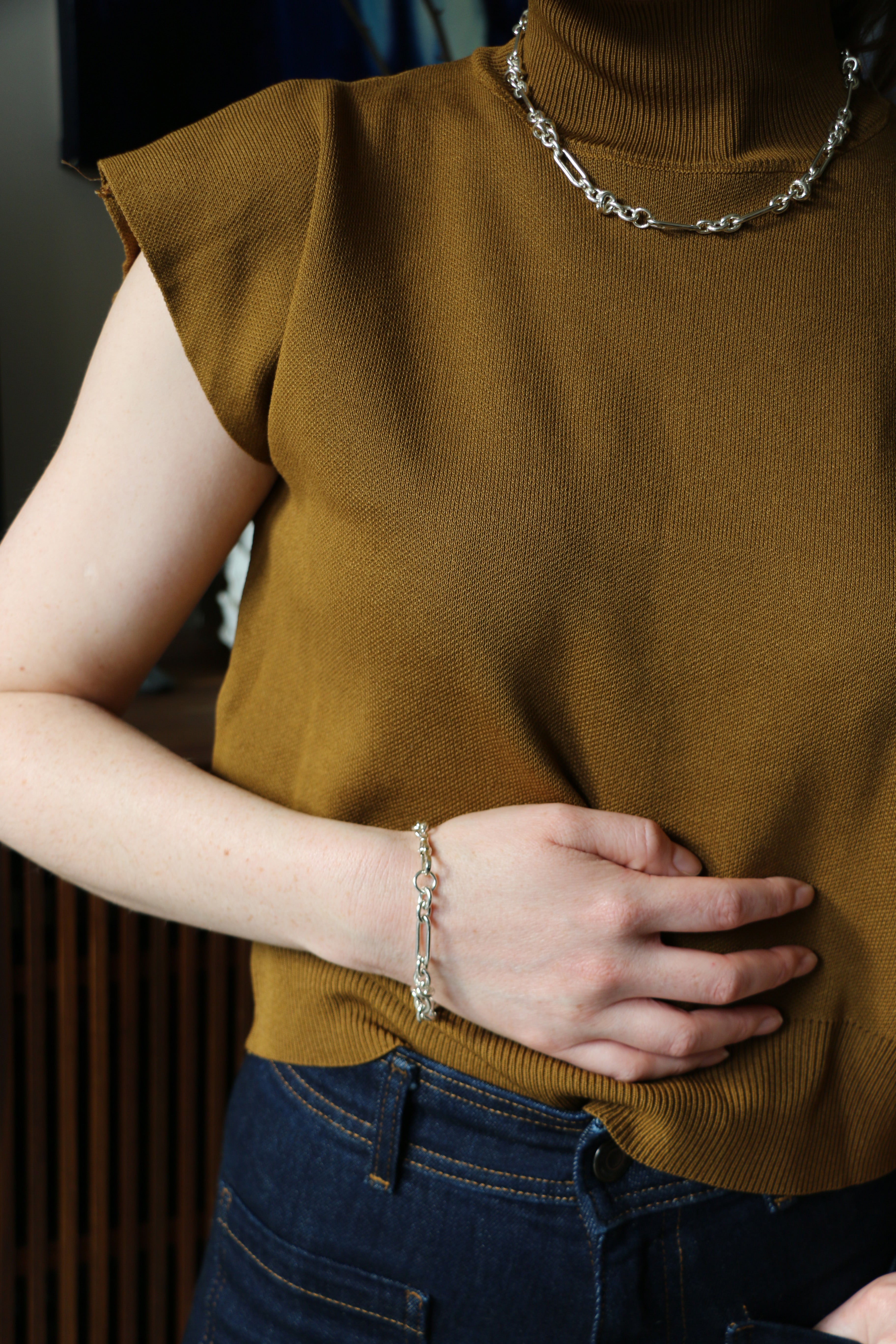 Model wearing jeans and silver Artemisia Chain bracelet and necklace with hands in her pocket