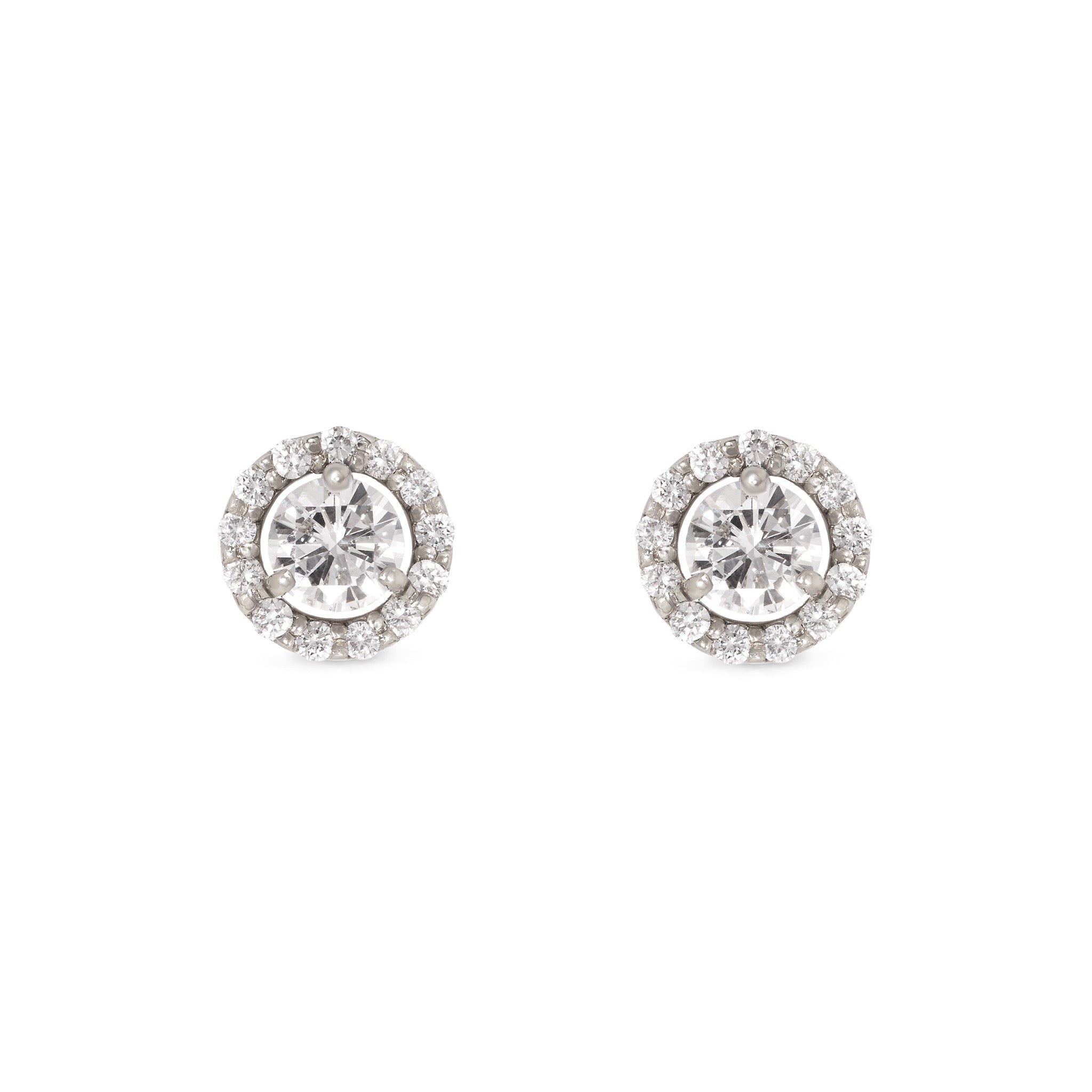 Diamond halo studs set in 14ct white gold lying on white background with shadow