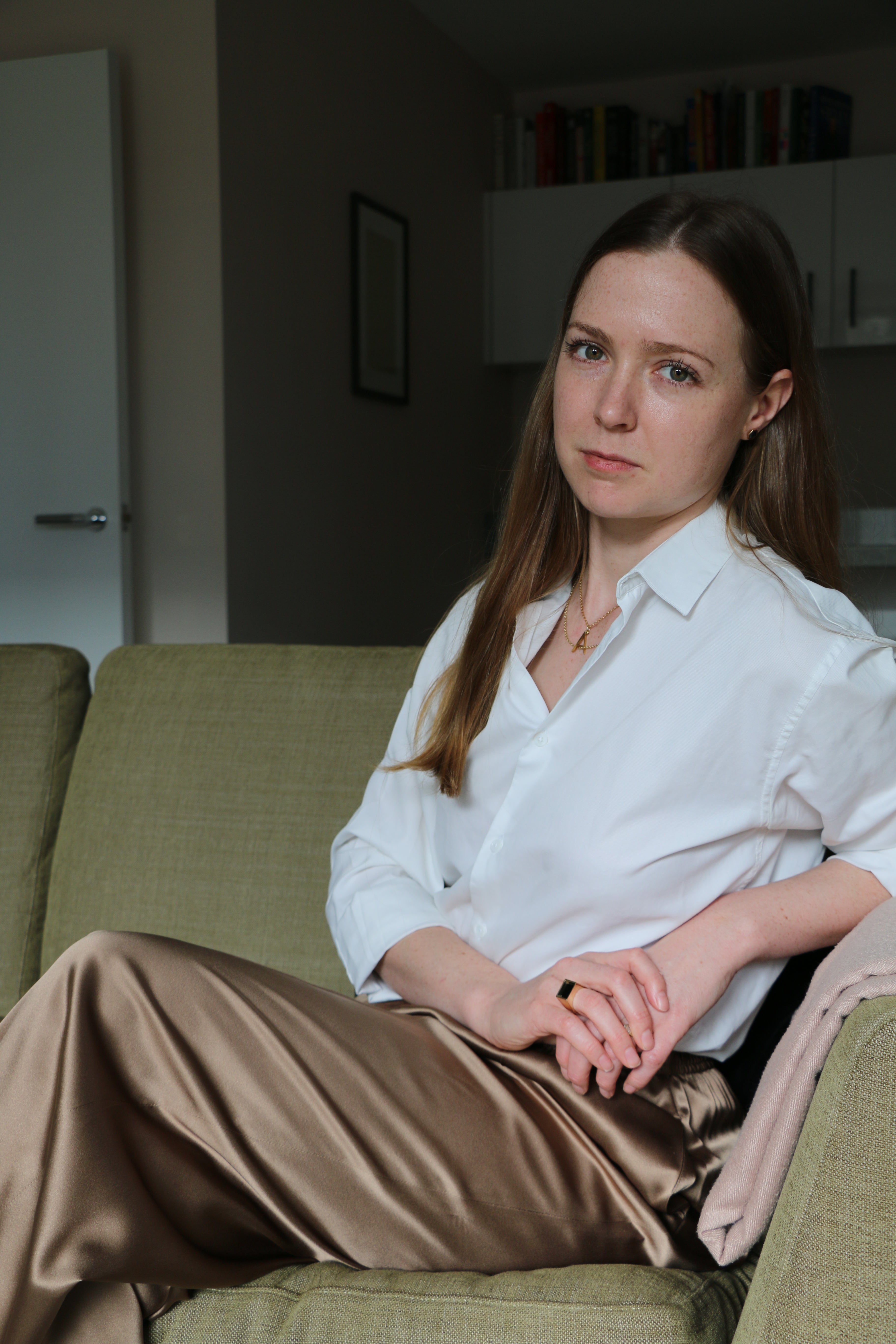 A portrait of our founder Antonia looking to the camera, wearing a white shirt and selection of our jewellery