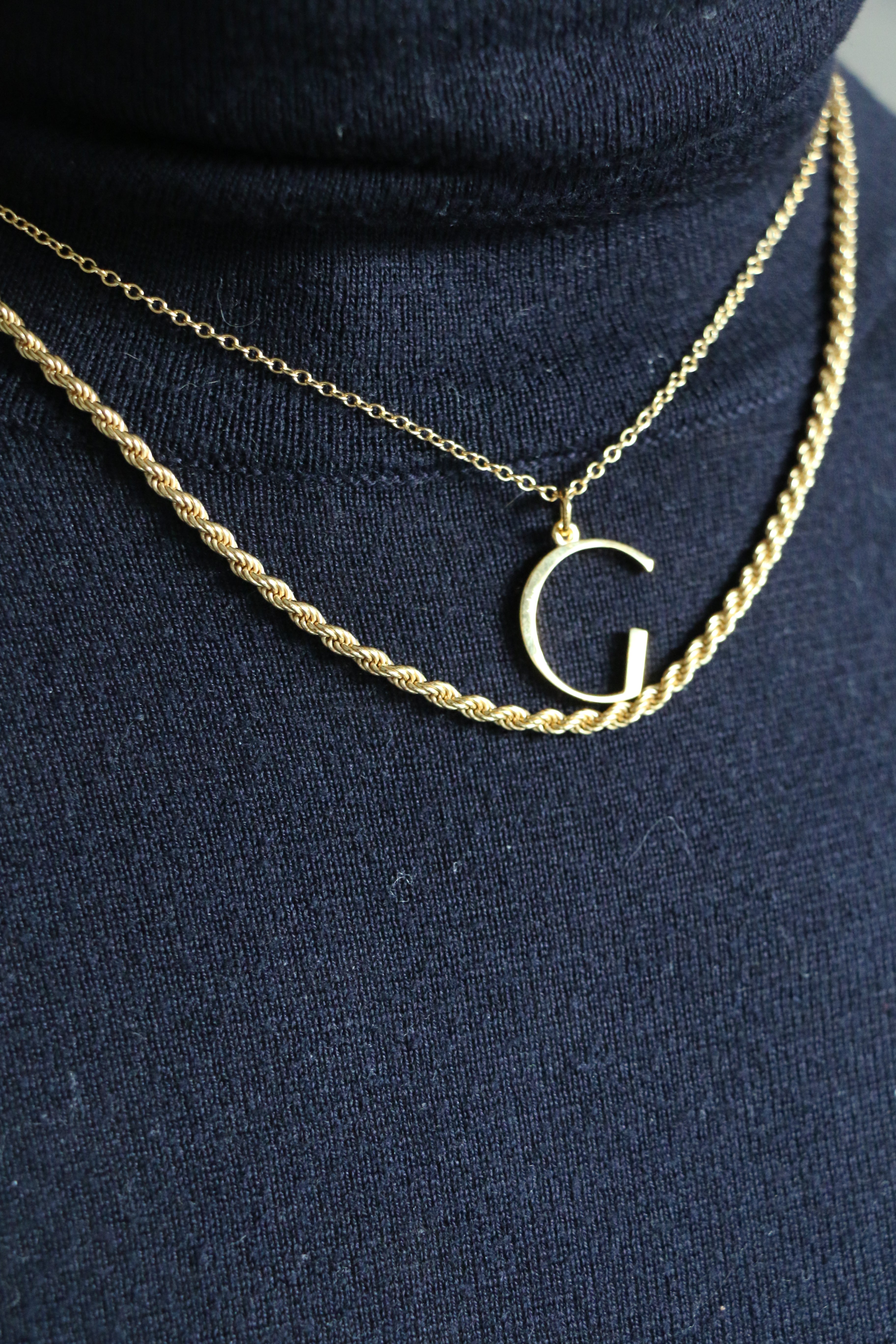 G initial Necklace and Rosalind Chain worn by model wearing blue polar neck