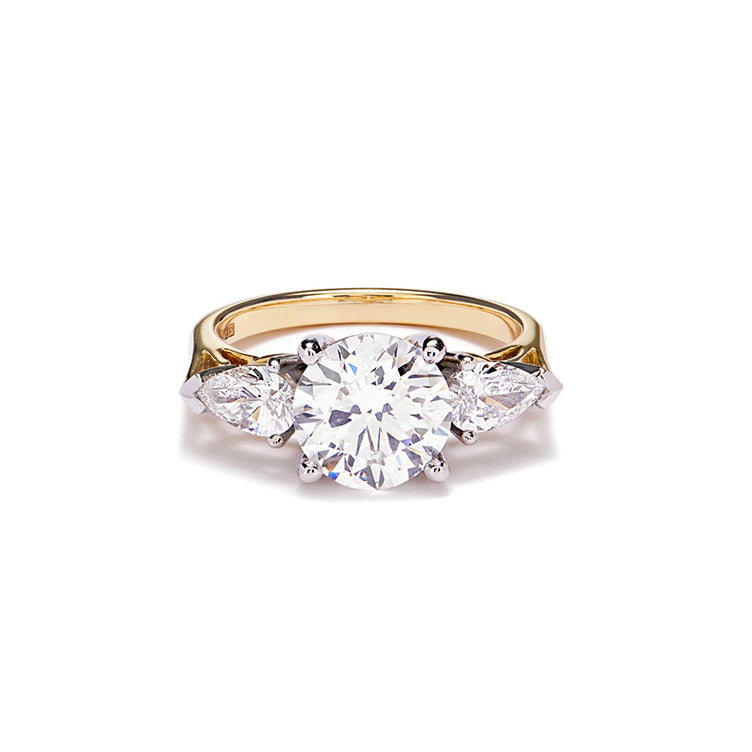 A stunning trilogy diamond engagement ring shown on a white cut out with shadow