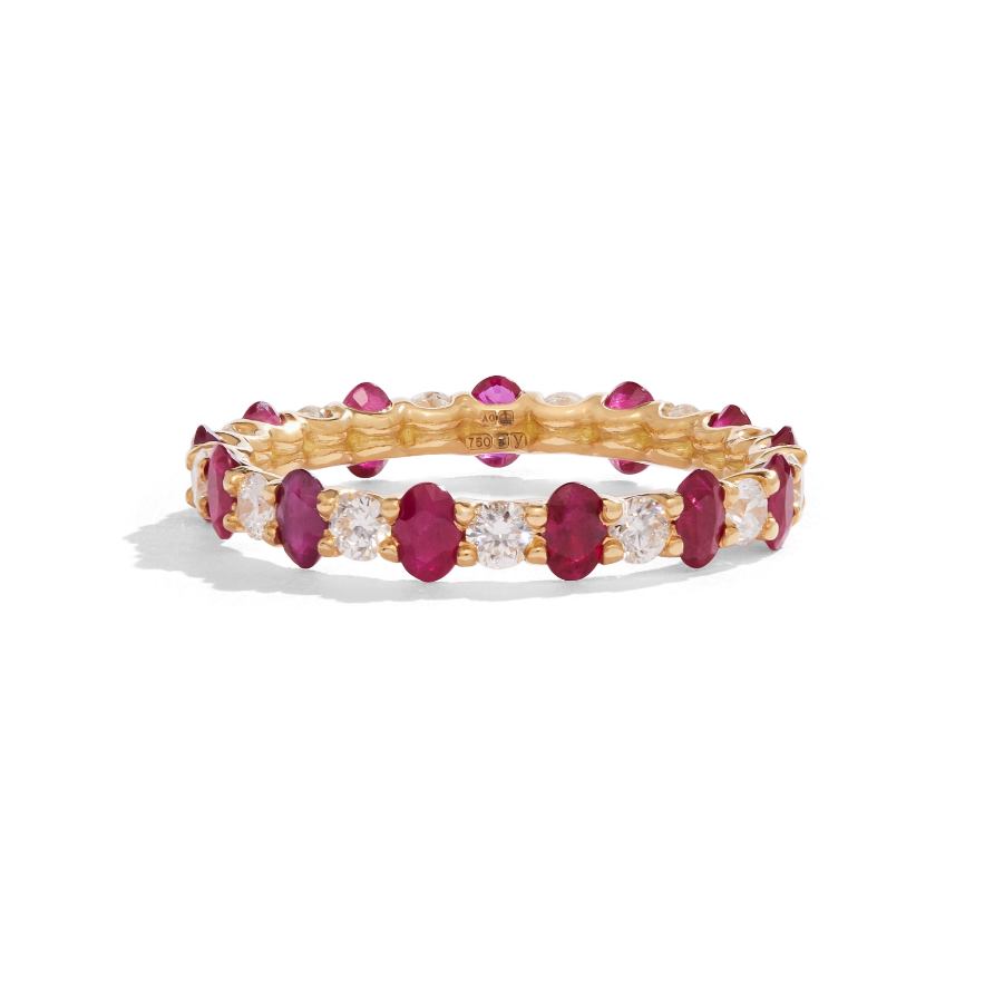 Ruby and diamond eternity ring set in 18ct yellow gold lying on white background with shadow