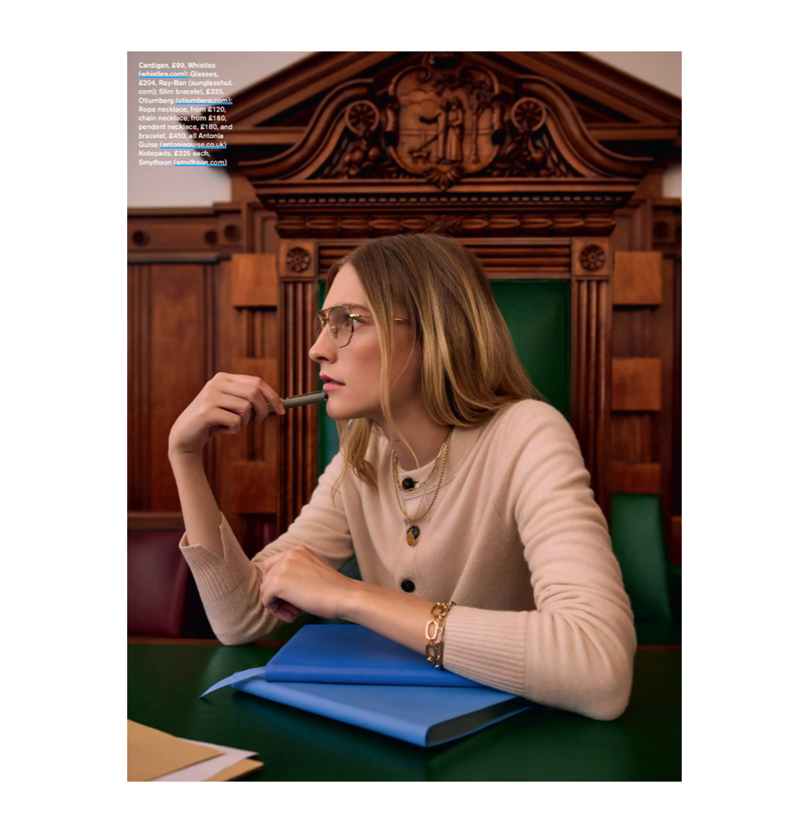 Image of Antonia Guise jewellery in Stylist Magazine feature. Model is wearing camel cardigan and sitting in a court room.