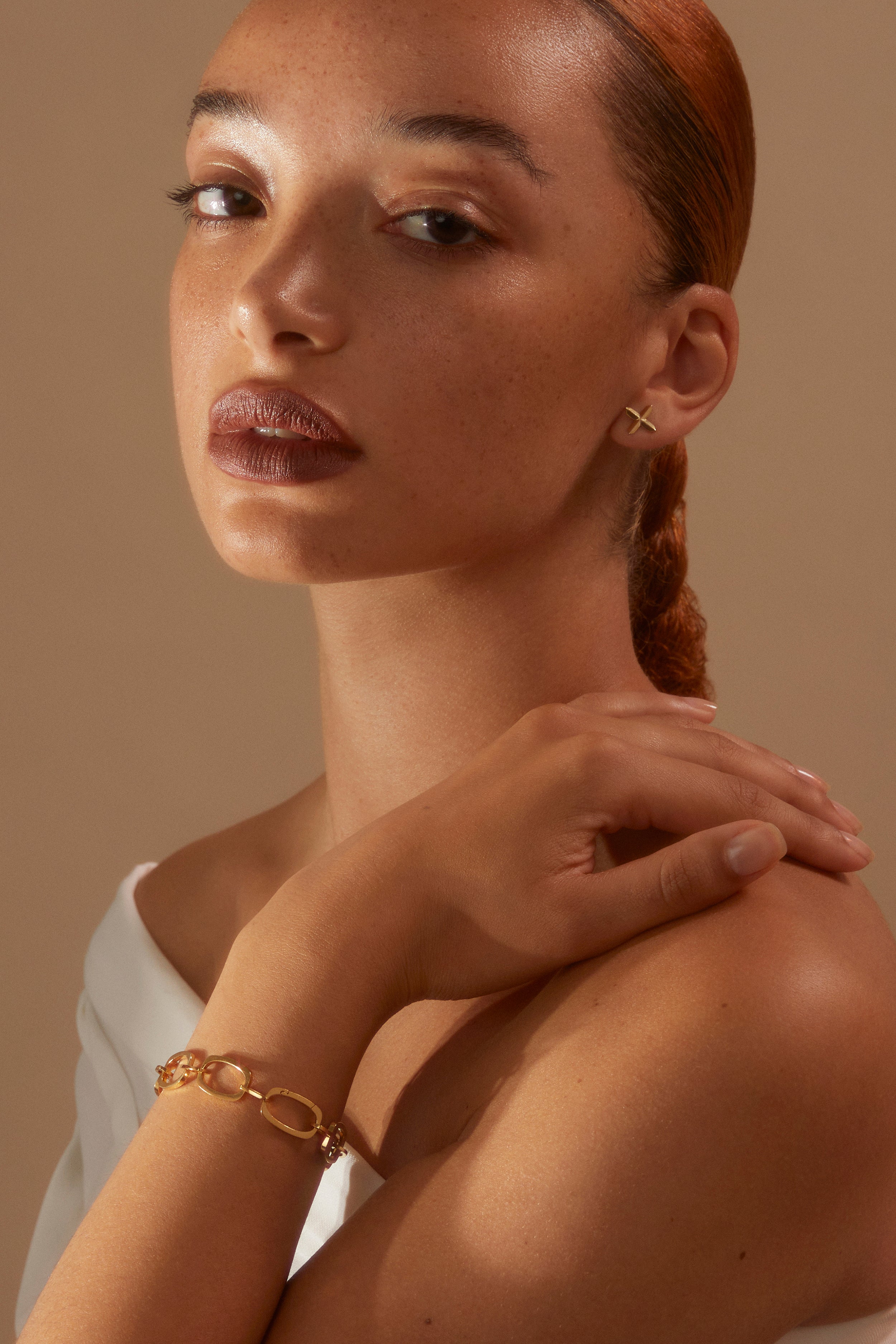 Model looking to camera wearing our gold vermeil Nancy Chain Bracelet