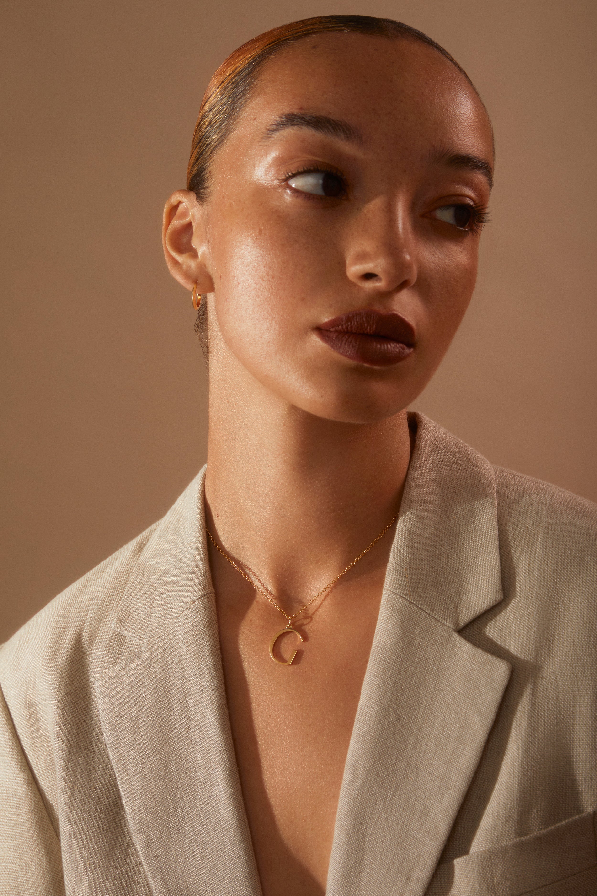 Model wearing nude linen jacket and our G initial Necklace