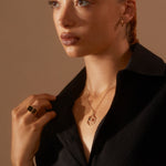 Model wearing Antonia Guise jewellery and Eve Signet Ring looking into distance