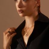 Model wearing Antonia Guise jewellery and Eve Signet Ring looking into distance