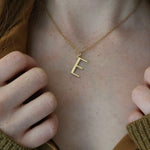 Close up of model wearing E necklace