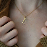Close up of model wearing E necklace