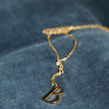 B Initial Necklace laid out on blue velvet