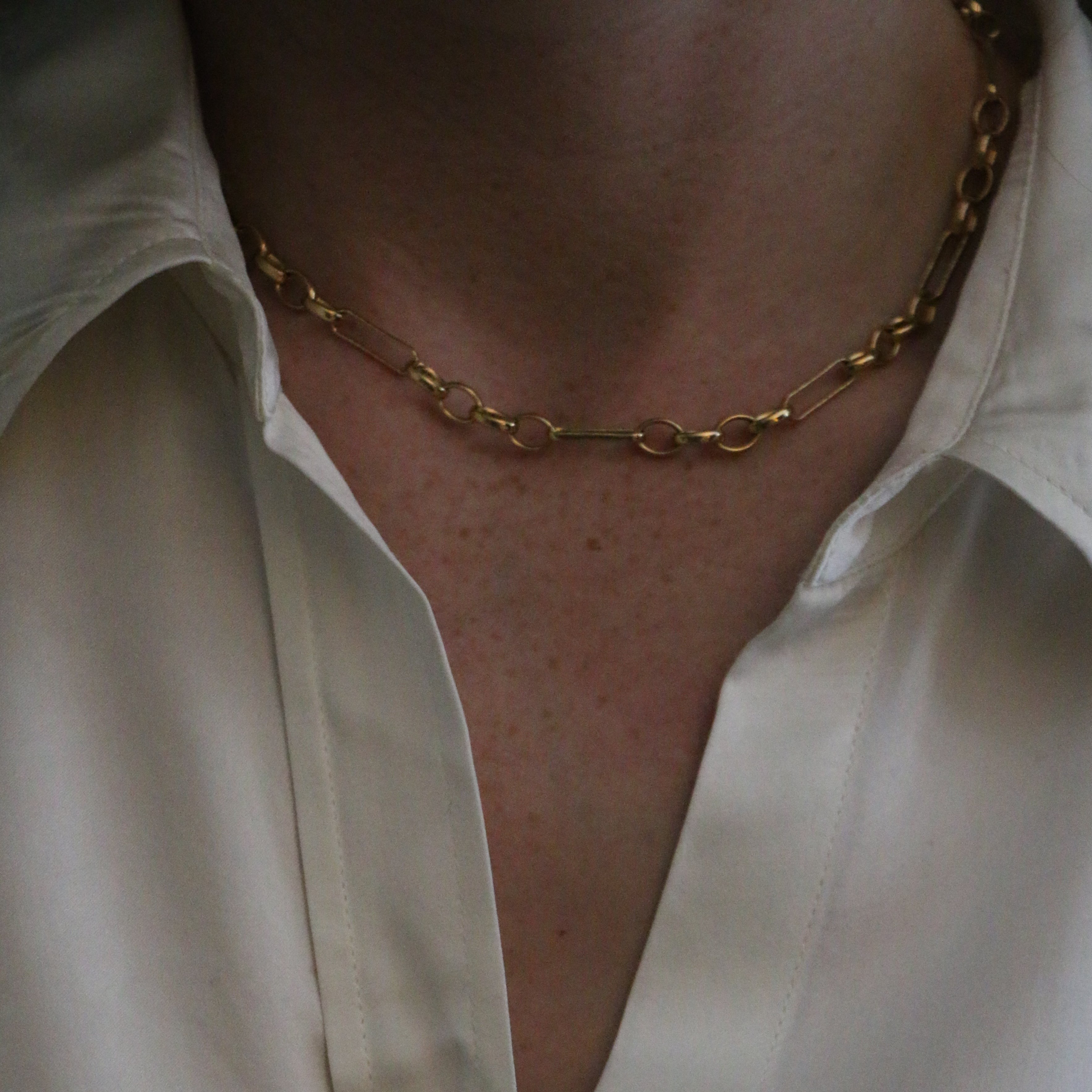 Close up of our Mary Figaro Necklace worn by model wearing a silk collared shirt