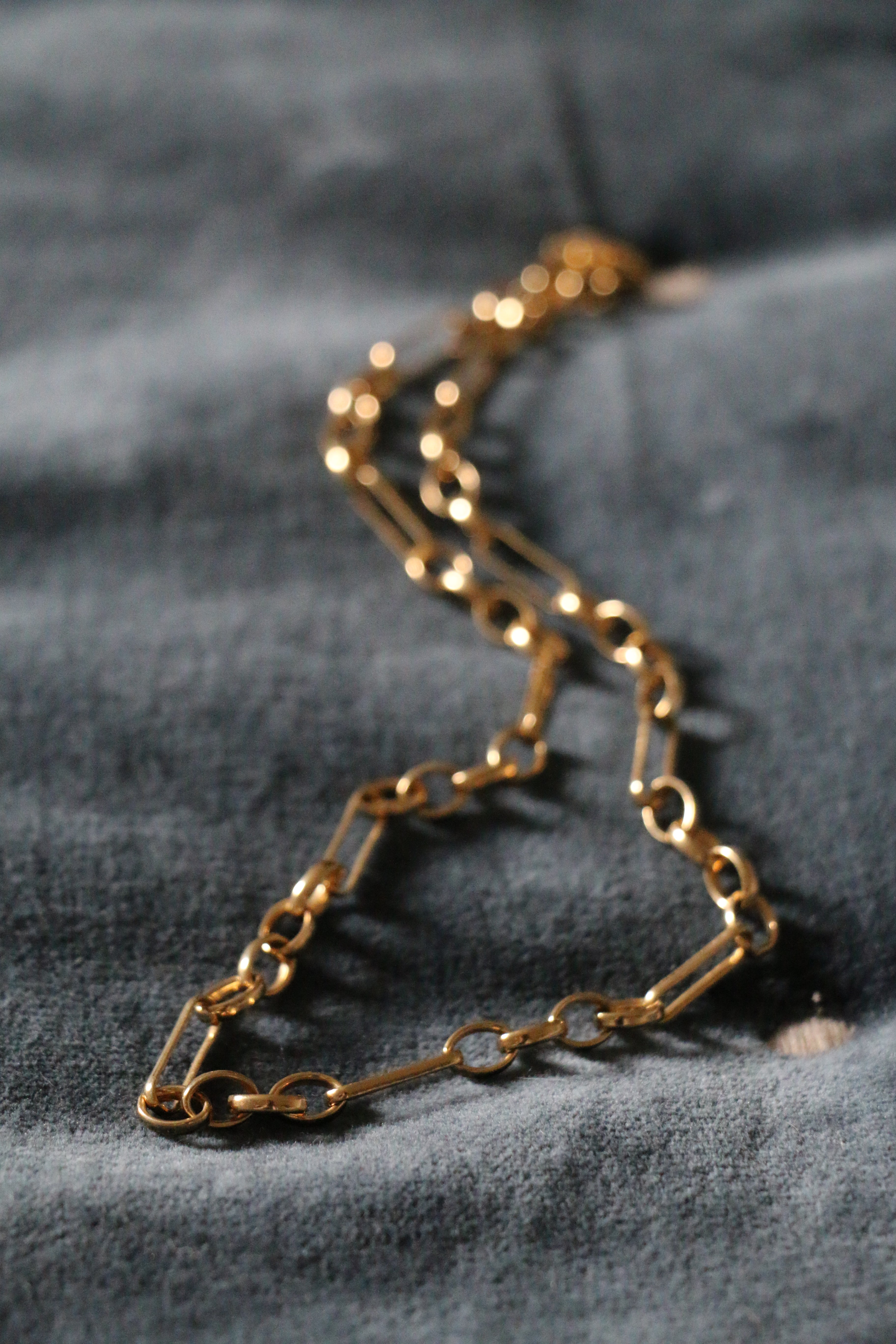 Antonia Guise Mary Figaro Chain lying on a blue velvet surface