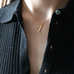L Necklace worn by model with black collared top