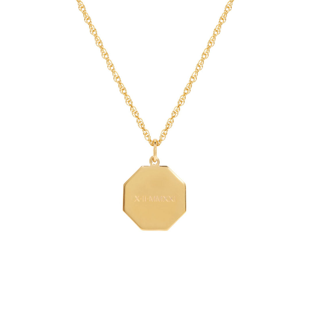 Engraved octagon gold vermeil pendant hanging on a gold chain on white background