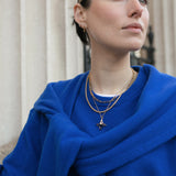 Close up of model in front of fluted columns wearing an assortment of Antonia Guise Gold Vermeil Jewellery
