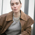 Image of model looking to camera wearing our gold vermeil., handmade Rosalind + Jenny Layering set