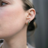 Close up shot of model wearing gold huggie hoops with a knife edge