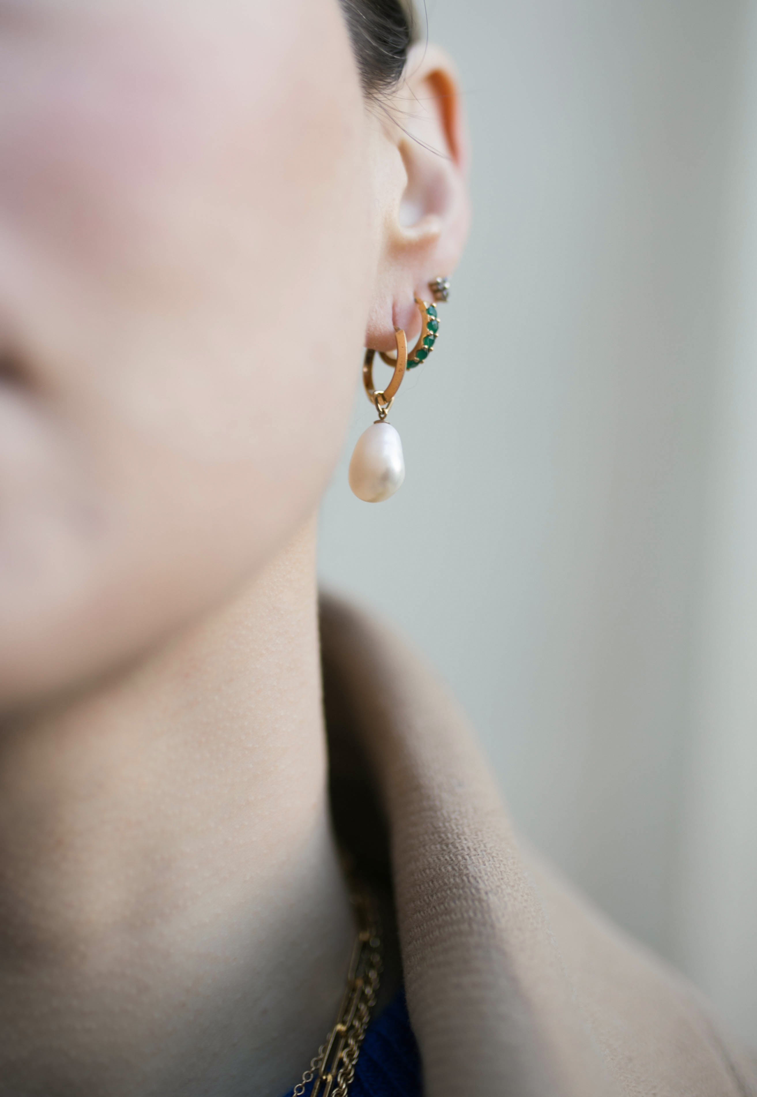 Close up of Cecilia Huggie Hoops and Hedy Pearl Drops along with other studs