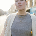 Model looking to camera wearing a white knit cardigan and our Mary Figaro 16 inch chain and Marlene T-Bar Necklace