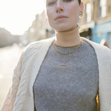 Model looking to camera wearing a white knit cardigan and our Mary Figaro 16 inch chain and Marlene T-Bar Necklace