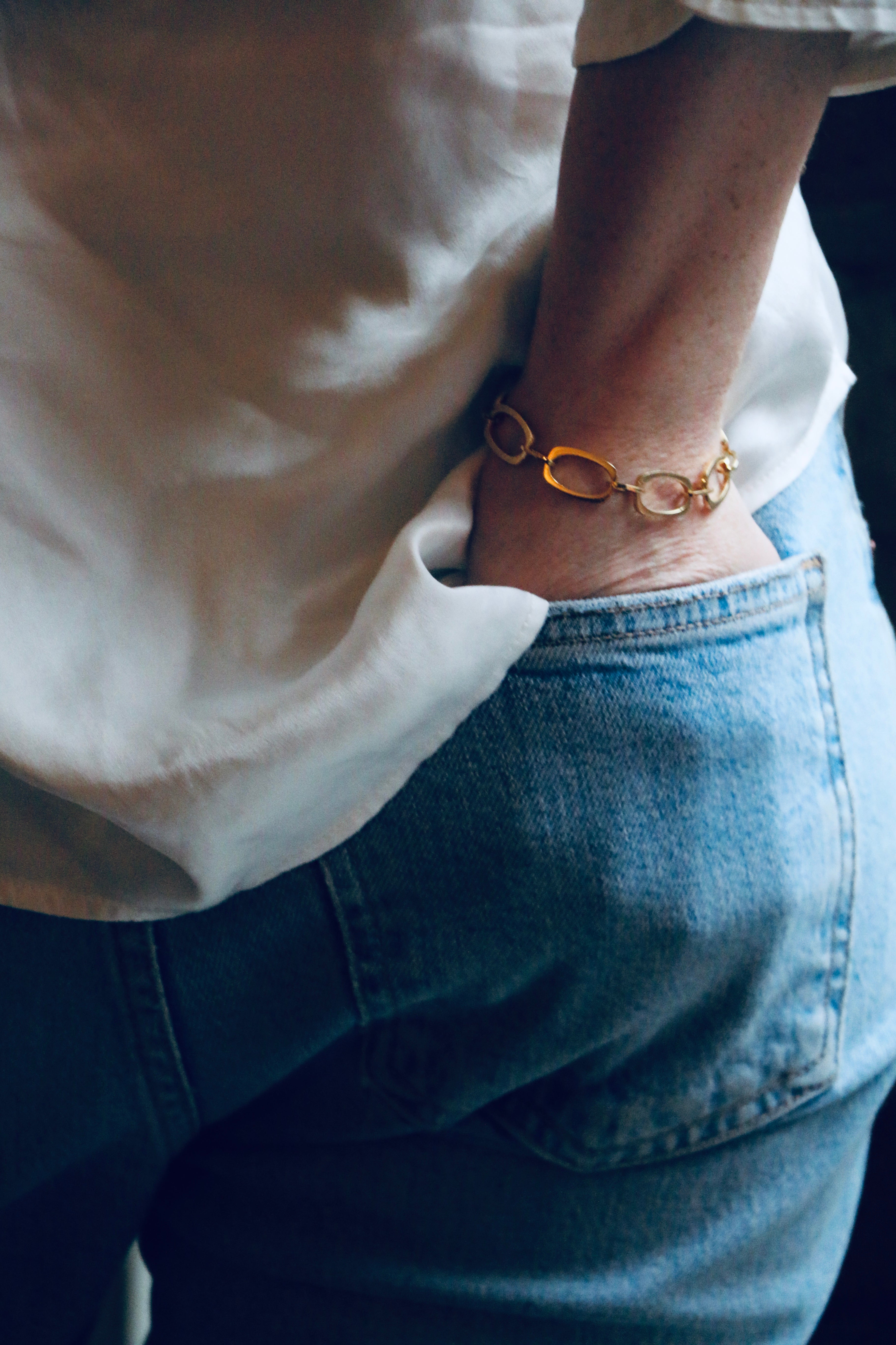 Image of model wearing blue jeans and white silk shirt along with our handmade Nancy Chain Bracelet