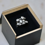 A multi-stone diamond cocktail ring in it's black presentation box