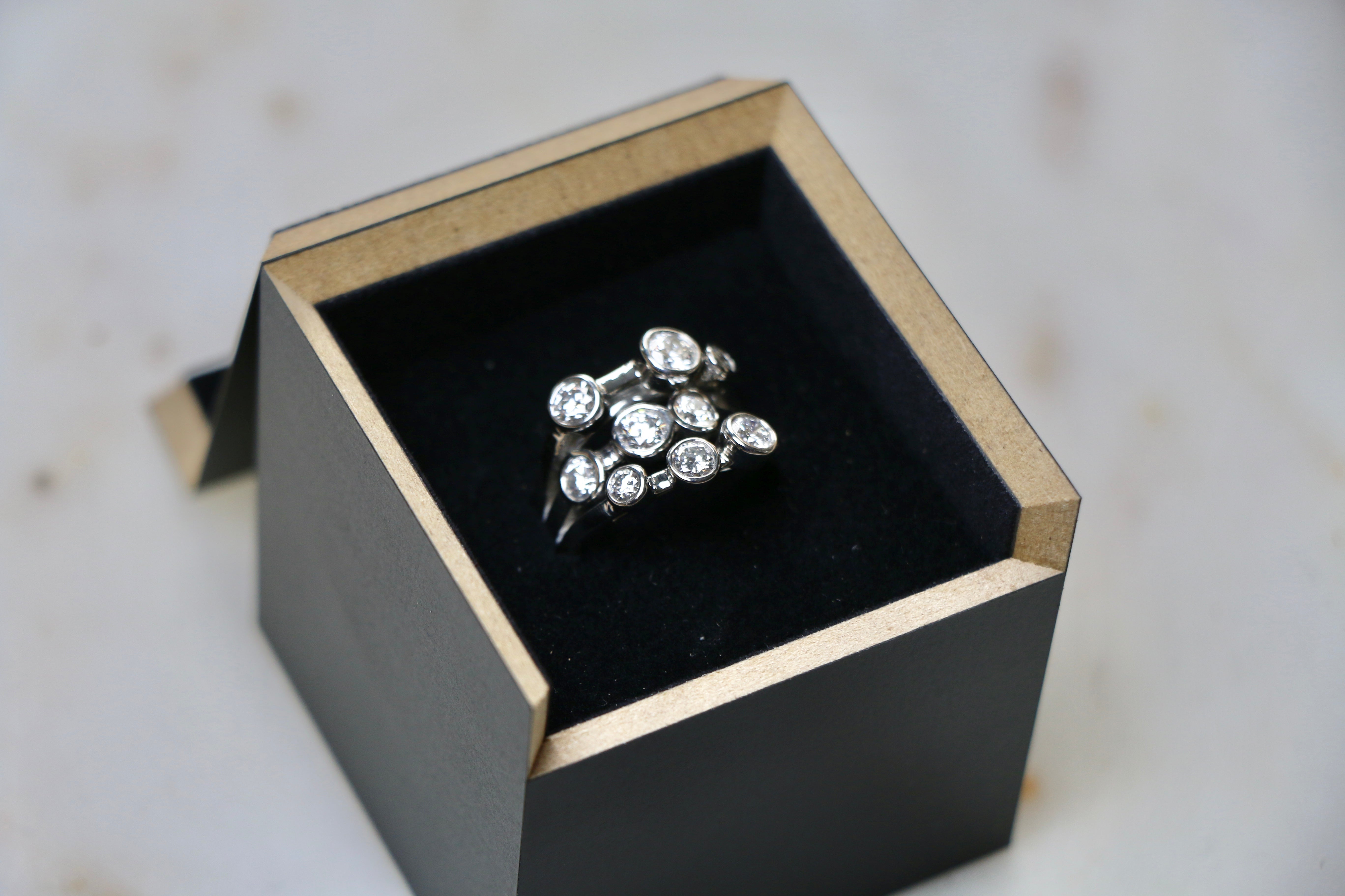 A multi-stone diamond cocktail ring in it's black presentation box