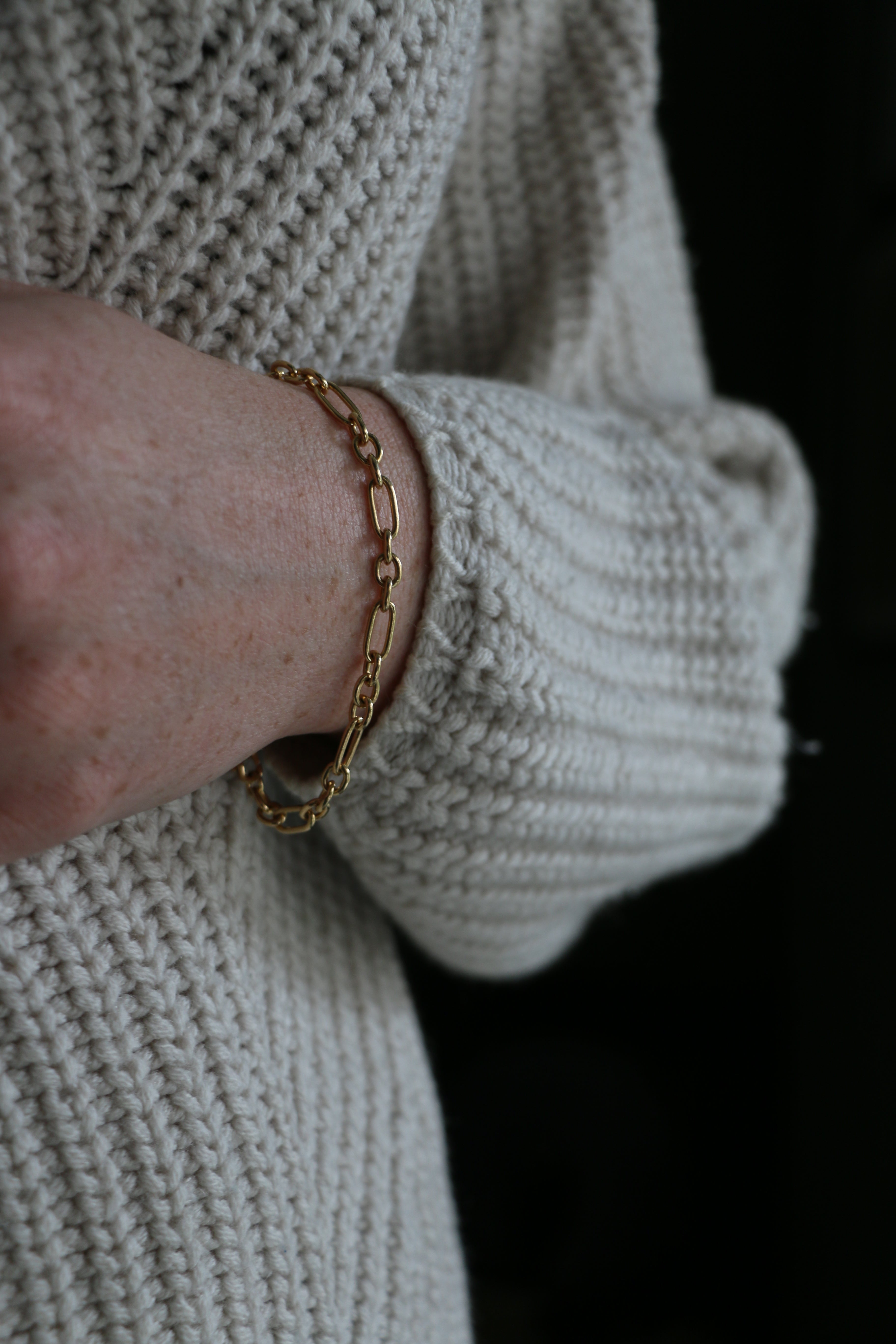 Close up of model wearing white knit jumper and our handmade Mary Figaro Bracelet
