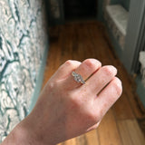 Image of model wearing the ring in a corridor with green patterned wallpaper 