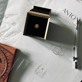 Image of signet ring in our presentation box sitting on Antonia's desk with hand drawn designs