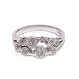 14ct white gold, split shank diamond ring with bezel set multi-stone lying on a white background