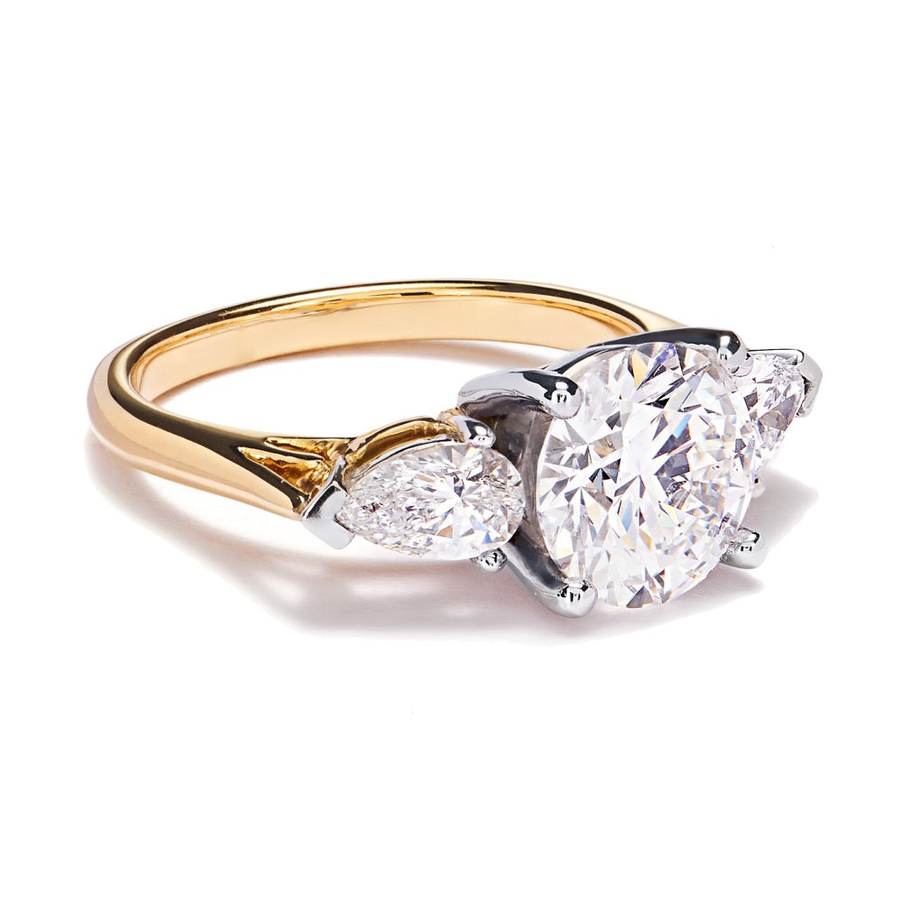 Trilogy, 18ct yellow gold and platinum  diamond ring with gallery detailing lying at an angle on a white background