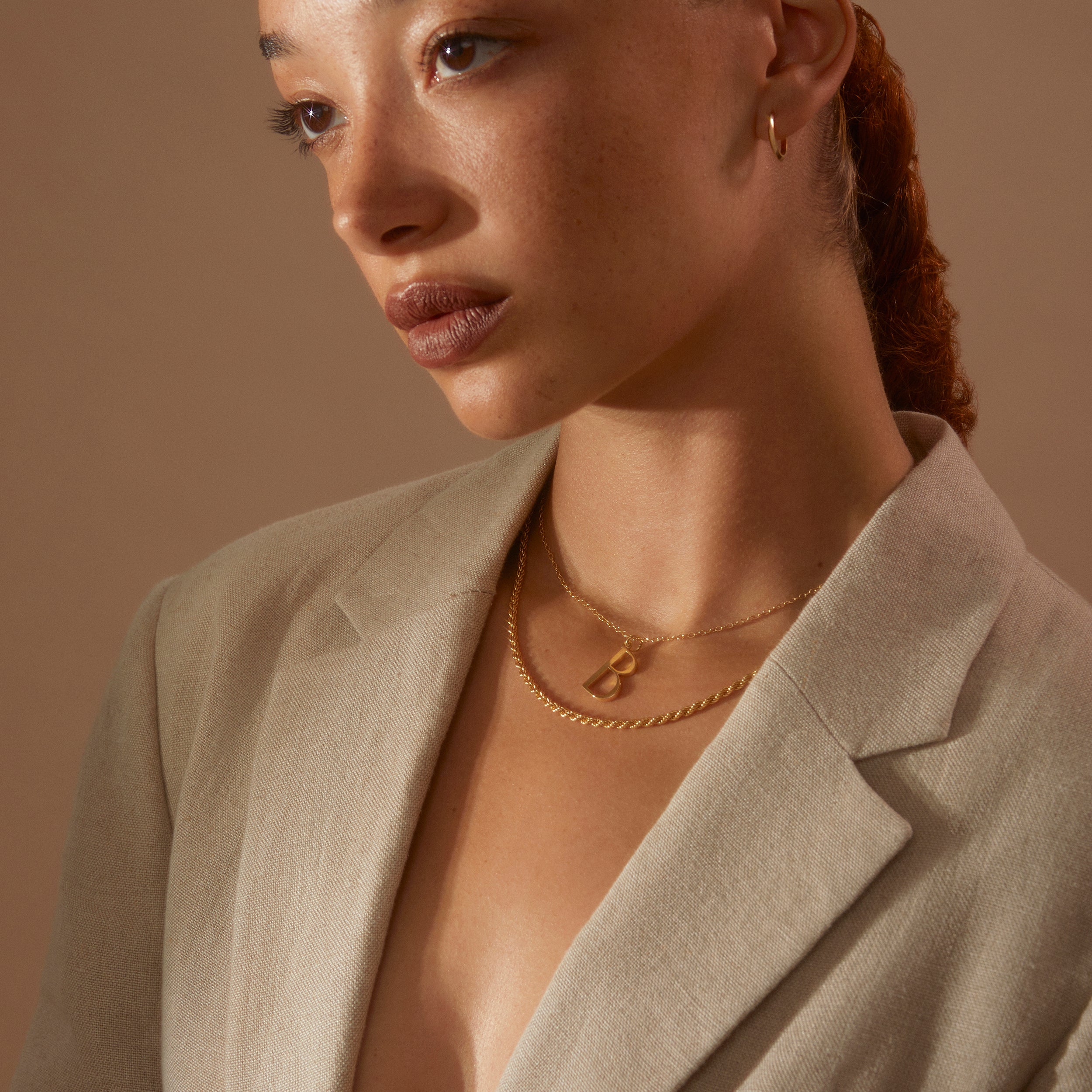 B Anne Initial worn by a model wearing a nude blazer and our Rosalind Chain Necklace