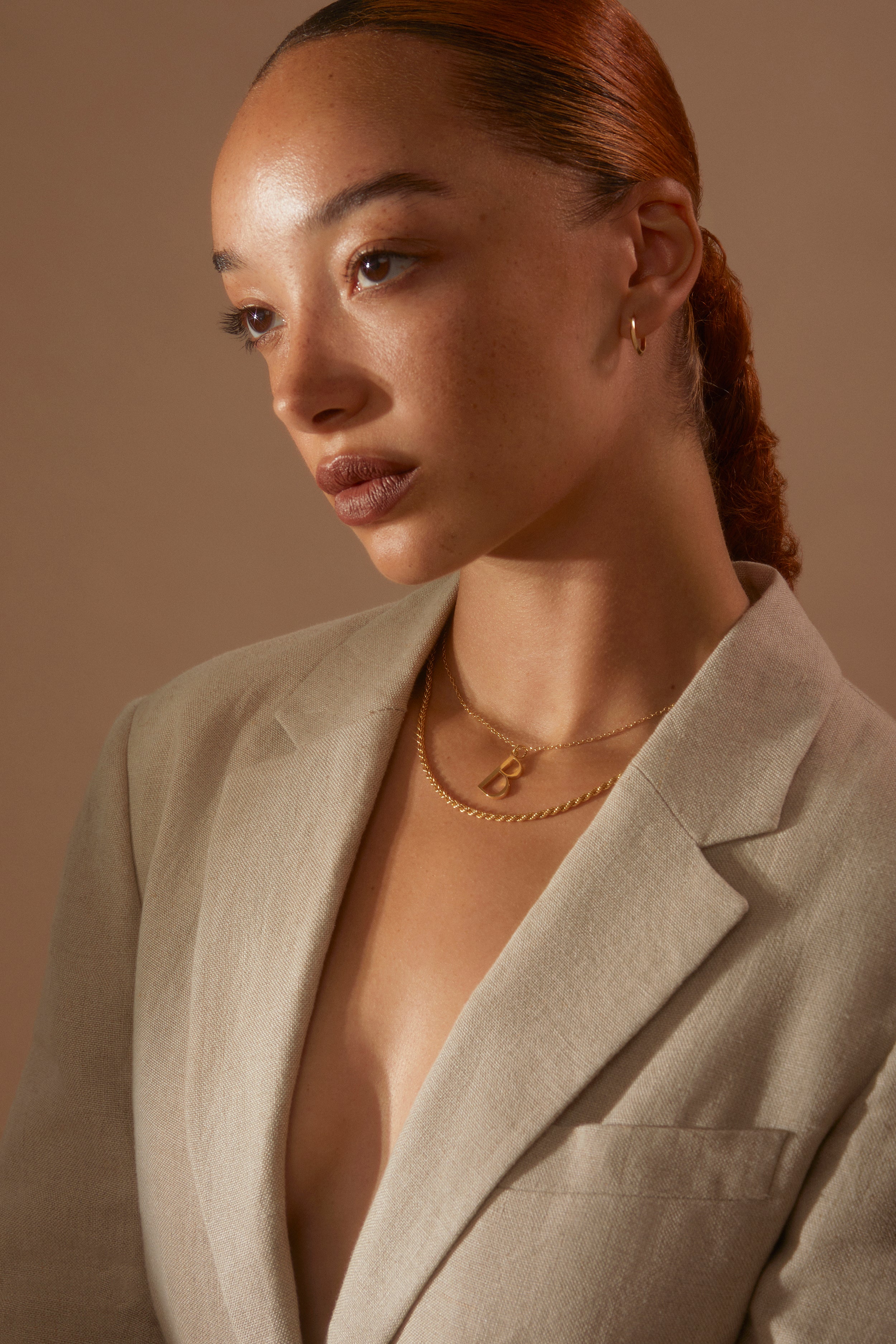 Model wearing linen blazer and a selection of Antonia Guise Necklace along with a pair of Gold Huggie Hoops