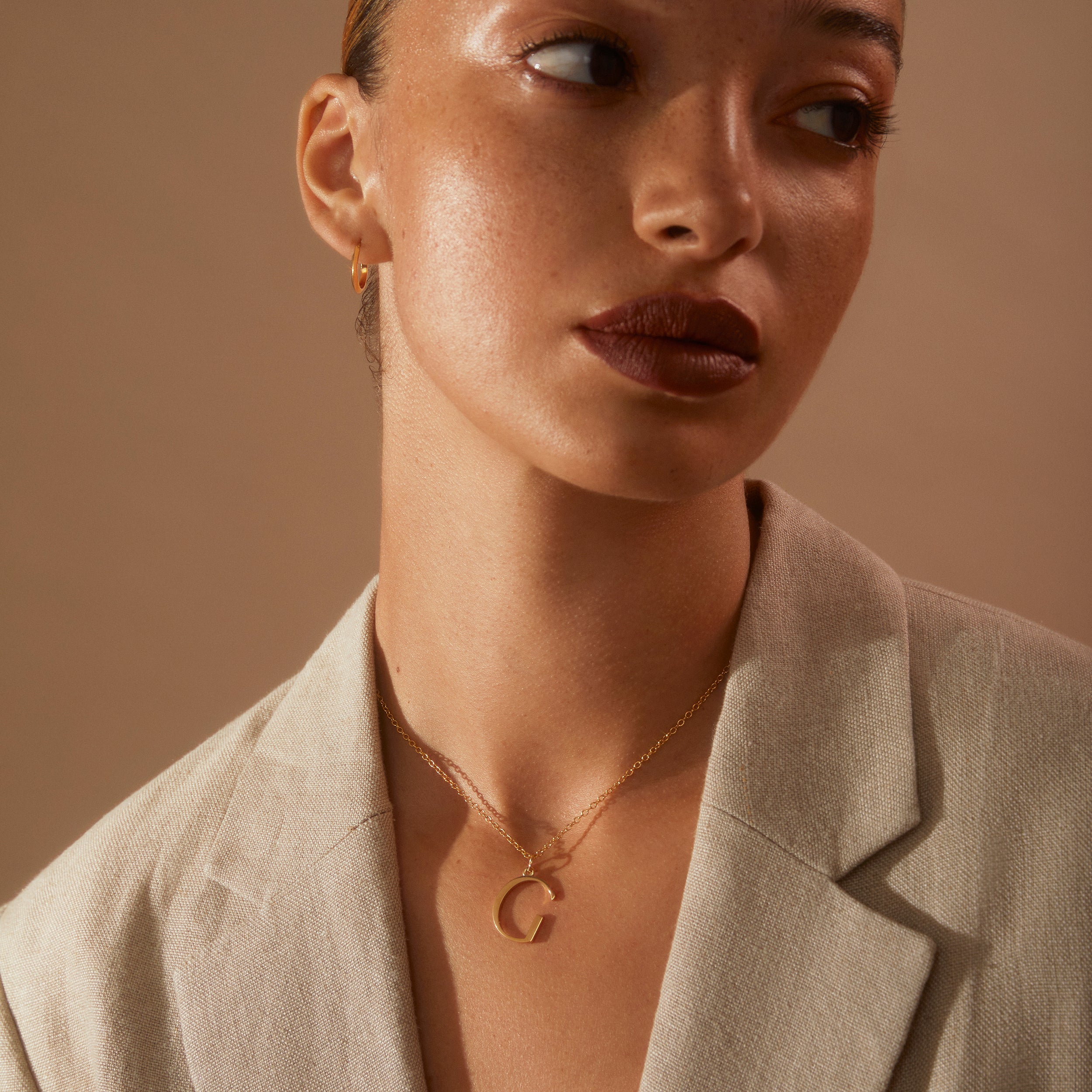 Model wearing nude linen jacket and our G initial Necklace