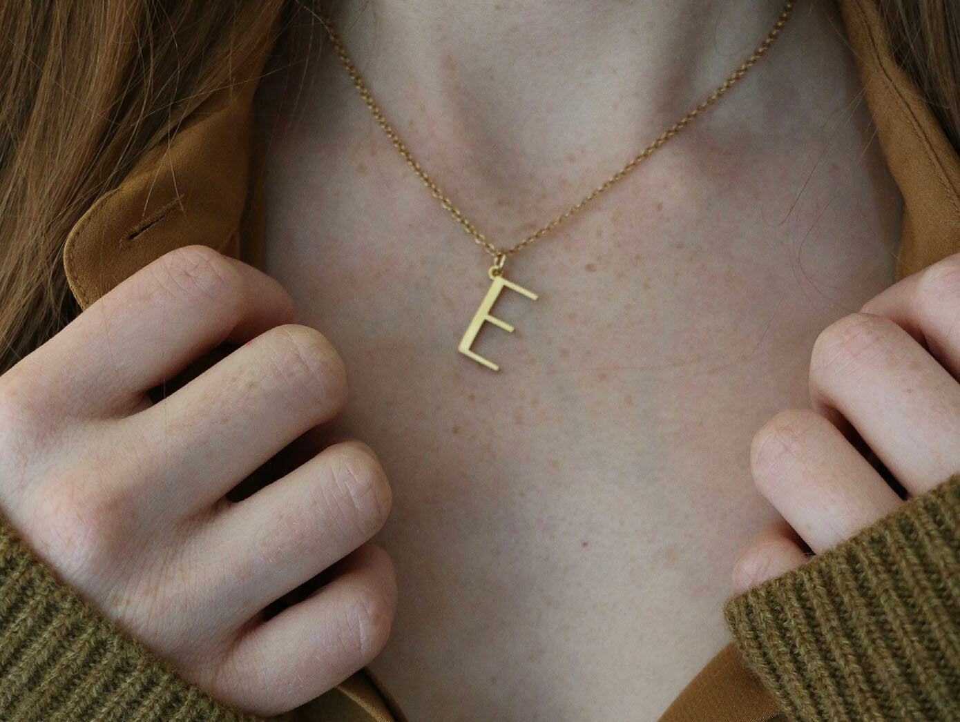 Close up of model wearing E necklace