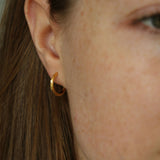 Close up shot of model wearing our Cecilia Gold Huggie Hoops
